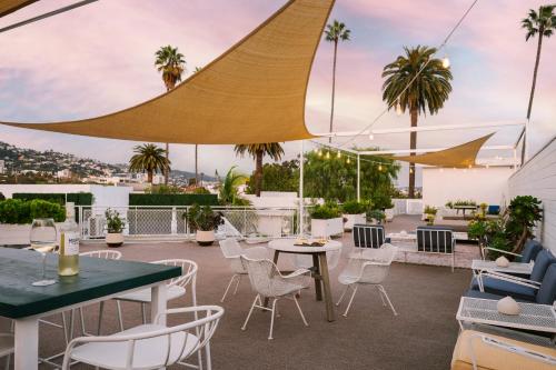 洛杉矶Beverly Terrace powered by Sonder的一个带桌椅的庭院,棕榈树