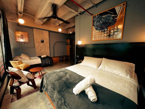 麦德林Viajero Medellin Hostel的一间卧室配有一张床、一张沙发和一把椅子