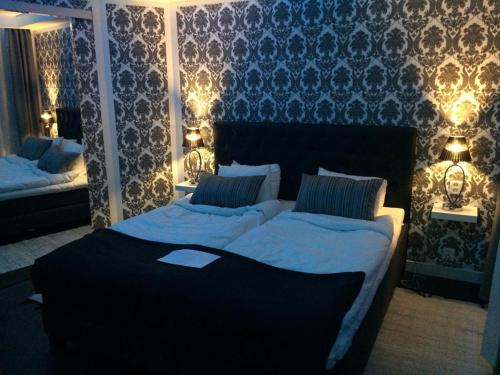 SkänningeSkänninge stadshotell的卧室配有两张带灯的墙壁床。