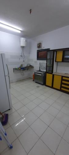 麦地那العنبرية4的厨房设有黄色橱柜和白色瓷砖地板。