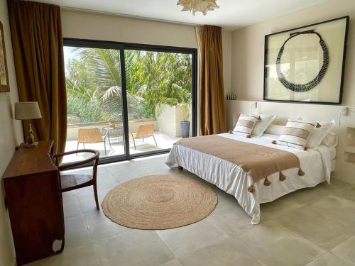 恩加帕鲁Villa YEMAYA - Villa d'hôtes的一间卧室设有一张大床和一个大窗户
