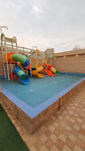 Qarārشاليهات العاب مائية للأطفال بالدرب的一个带水上滑梯的水上公园的游泳池
