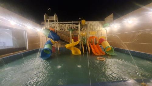 Qarārشاليهات العاب مائية للأطفال بالدرب的一个带水上滑梯的水上公园的游泳池