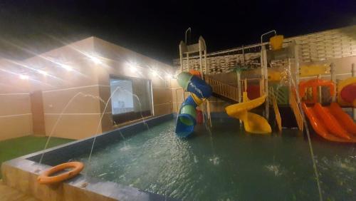 Qarārشاليهات العاب مائية للأطفال بالدرب的一个带游泳池的水上公园,游泳池设有水滑梯
