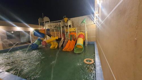 Qarārشاليهات العاب مائية للأطفال بالدرب的一个带水上公园的游泳池,带游乐场