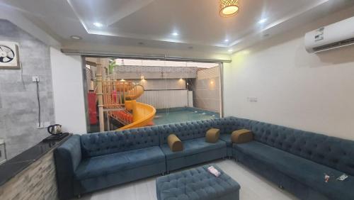 Qarārشاليهات العاب مائية للأطفال بالدرب的客厅设有蓝色的沙发和游乐场。