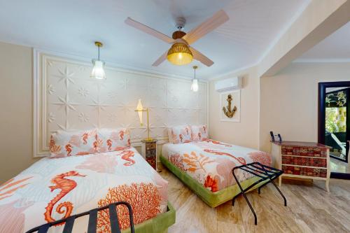 坎昆Villas Tropical 11的一间卧室配有两张床和吊扇