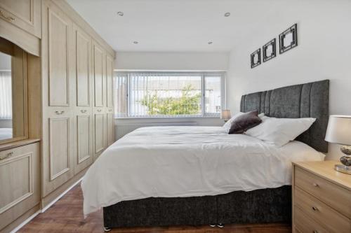 曼彻斯特house in Heald Green village的一间卧室设有一张大床和一个窗户。