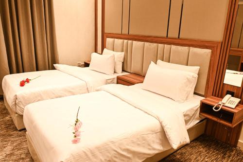 吉达بيوت ملاذ للشقق الفندقية的配有白色床单的酒店客房内的两张床