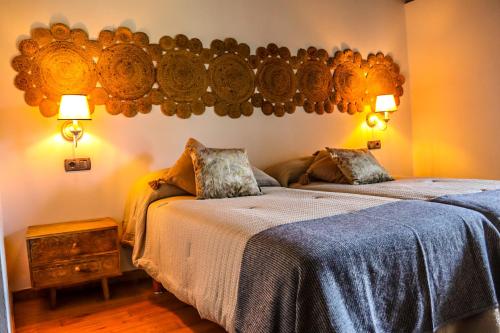 阿尔苏阿Fogar de Lecer的一间卧室设有两张床,墙上有两盏灯。