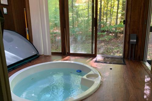 莱克哈莫尼Alpine Allure by AvantStay Indoor Hot Tub Game Loft Enclosed Deck的带浴缸的大窗户