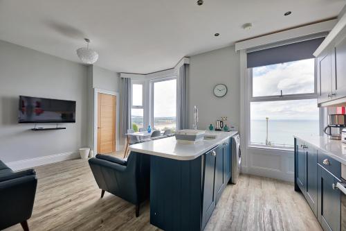 斯卡伯勒Bay View Holiday Apartments的一间设有蓝色橱柜的厨房,享有海景
