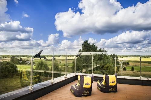 普伦盖波尔图酒店的阳台设有大窗户,享有田野美景。