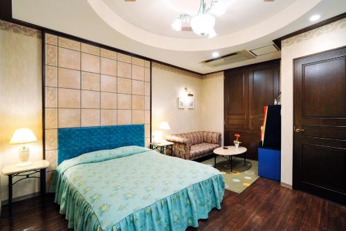 Shōmachiホテル　サンタモニカ(大人専用)的一间卧室配有蓝色的床和沙发