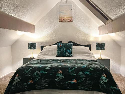StaintondaleCart Cottage - 28343的一间卧室配有一张大床和两盏灯。