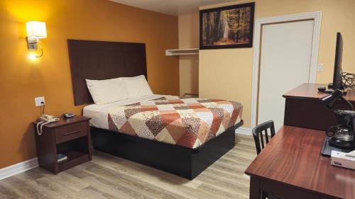Deep River迪普里弗汽车旅馆的酒店客房配有一张床、一张书桌和一台电视。
