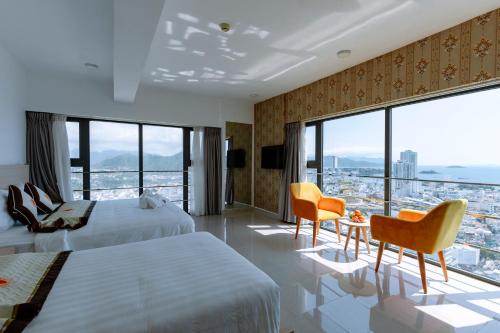 芽庄Napoleon Nha Trang Hotel的酒店客房设有两张床和大窗户。