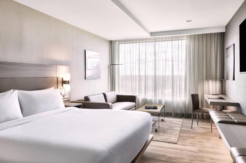布里奇沃特AC Hotel by Marriott Bridgewater的酒店客房配有白色的床和沙发。