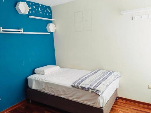 特鲁希略Exclusivo Apartamento en el Centro de Trujillo的小房间设有一张蓝色墙壁的床