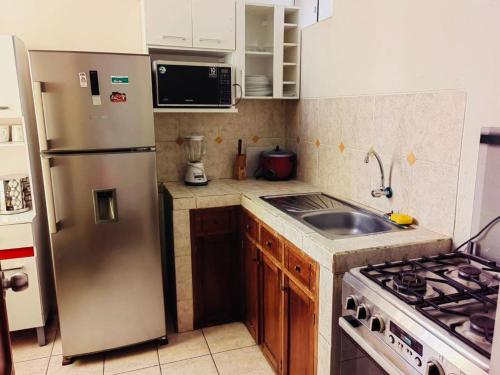 特鲁希略Exclusivo Apartamento en el Centro de Trujillo的厨房配有不锈钢冰箱和水槽