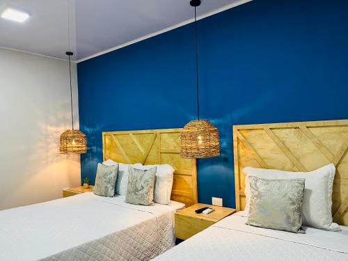 La LimaWE Hotel, La Lima的蓝色墙壁客房的两张床