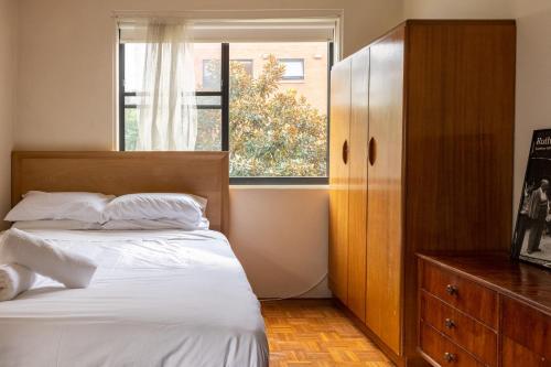 悉尼Light-Filled Paddington Studio with Parking的一间卧室设有一张床和一个窗口