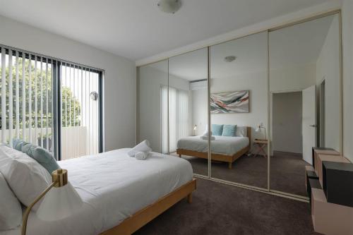 悉尼Treetops Camperdown Inner City Bliss w Parking的一间卧室配有一张床和一面大镜子