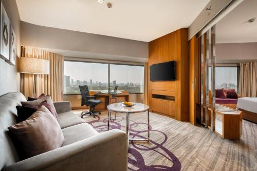 曼谷盛泰澜曼谷拉普崂中央广场酒店的酒店客房设有沙发和桌子