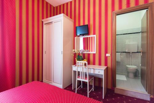 威尼斯梅斯纳尔酒店的客房设有书桌、卫生间和红色条纹