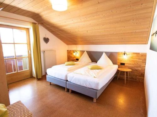 施万高Inviting holiday home with sauna的一间卧室设有一张带木制天花板的大床