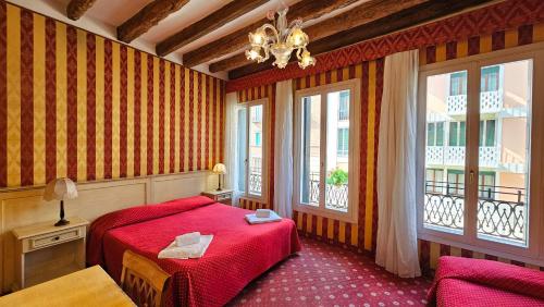 威尼斯梅斯纳尔酒店的一间卧室设有红色的床和2个窗户。