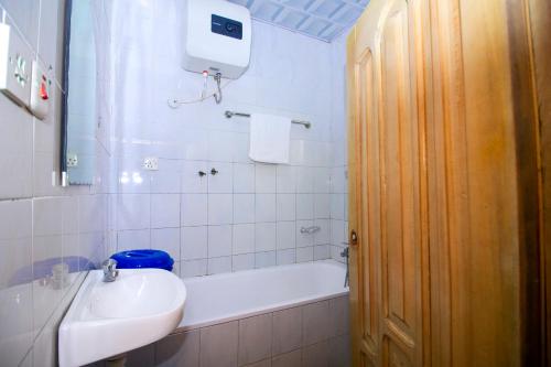 库马西PRESTIGE Guesthouse ,Ksi的浴室配有盥洗盆、卫生间和浴缸。