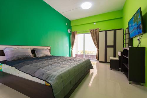 Ban Huai KrabokThe Bua Boutique Resort的绿色卧室配有床和平面电视