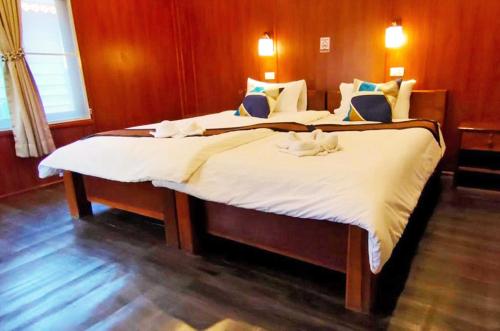 万荣Vang Vieng Garden Villa的一间卧室配有两张带白色床单的床