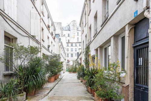 巴黎ParisMyHome - Air-conditioned, 2 shower rooms, 2 toilets的种植了盆栽植物和建筑的小巷