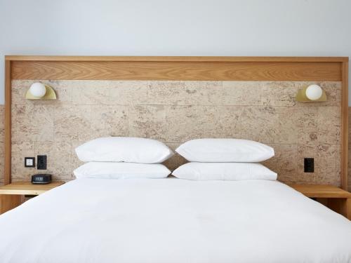 Mount PritchardGreen Valley Hotel的一张白色的床,上面有四个枕头