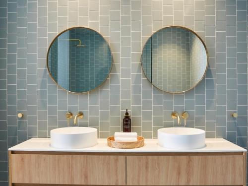 Mount PritchardGreen Valley Hotel的浴室设有两个水槽,墙上装有镜子