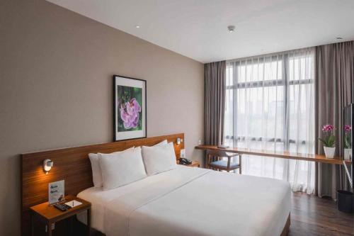 雅加达Veranda Serviced Residence Puri的一间设有大床和窗户的酒店客房