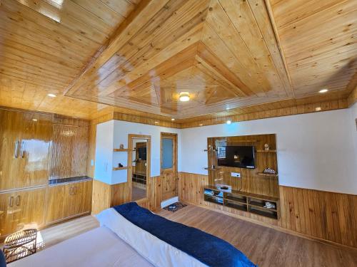 CheogZen Homestay的一间卧室设有木制天花板、一张床和一台电视机。