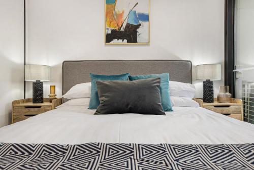 墨尔本Stay Near Botanic Garden with Gym, Sauna & Parking的卧室配有带蓝色枕头的大型白色床