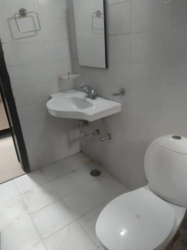 马图拉Apartment in Omaxe, Vrindavan的白色的浴室设有卫生间和水槽。