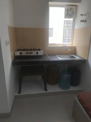 马图拉Apartment in Omaxe, Vrindavan的厨房配有炉灶、水槽和窗户。
