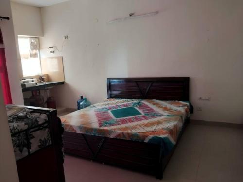 马图拉Apartment in Omaxe, Vrindavan的一间卧室配有床,床上装有被子