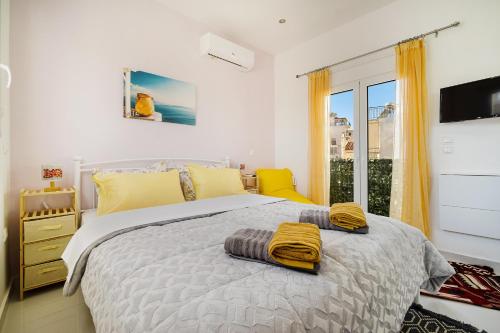 雅典Posh hood Rooftop with balconies的一间卧室配有一张黄色毛巾的床