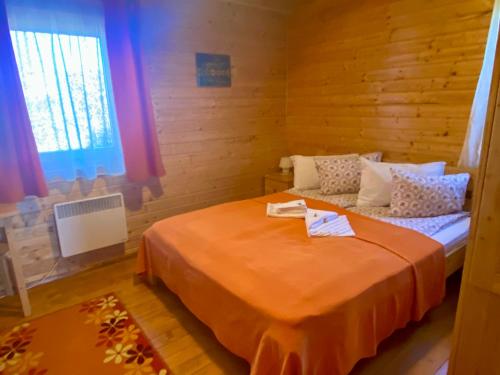 Păuleni-CiucNimfa Apartments的一间卧室配有一张带橙色毯子的床