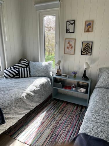 隆德Tiny house Lund的一间卧室配有一张床、一张桌子和一个窗户。