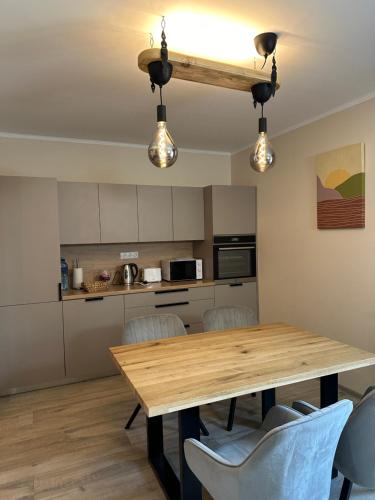 拉脱维亚Pie Jūras的厨房以及带木桌和椅子的用餐室。