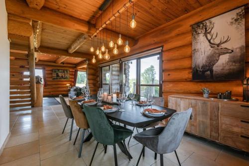 ZottegemBeautiful log home with stunning views的用餐室配有桌椅和墙上的鹿画