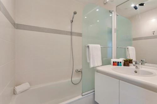 奥斯坦德Cosy apartment with amazing beach view的带淋浴和盥洗盆的白色浴室