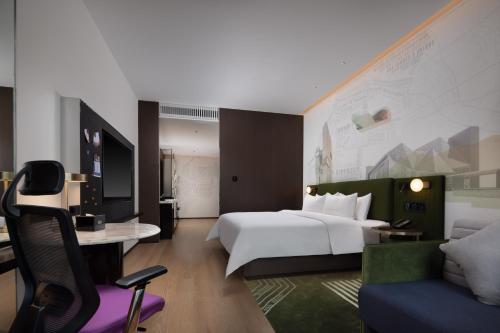 深圳深圳南山科技园希尔顿欢朋酒店的一间酒店客房,配有一张白色的床和一张书桌